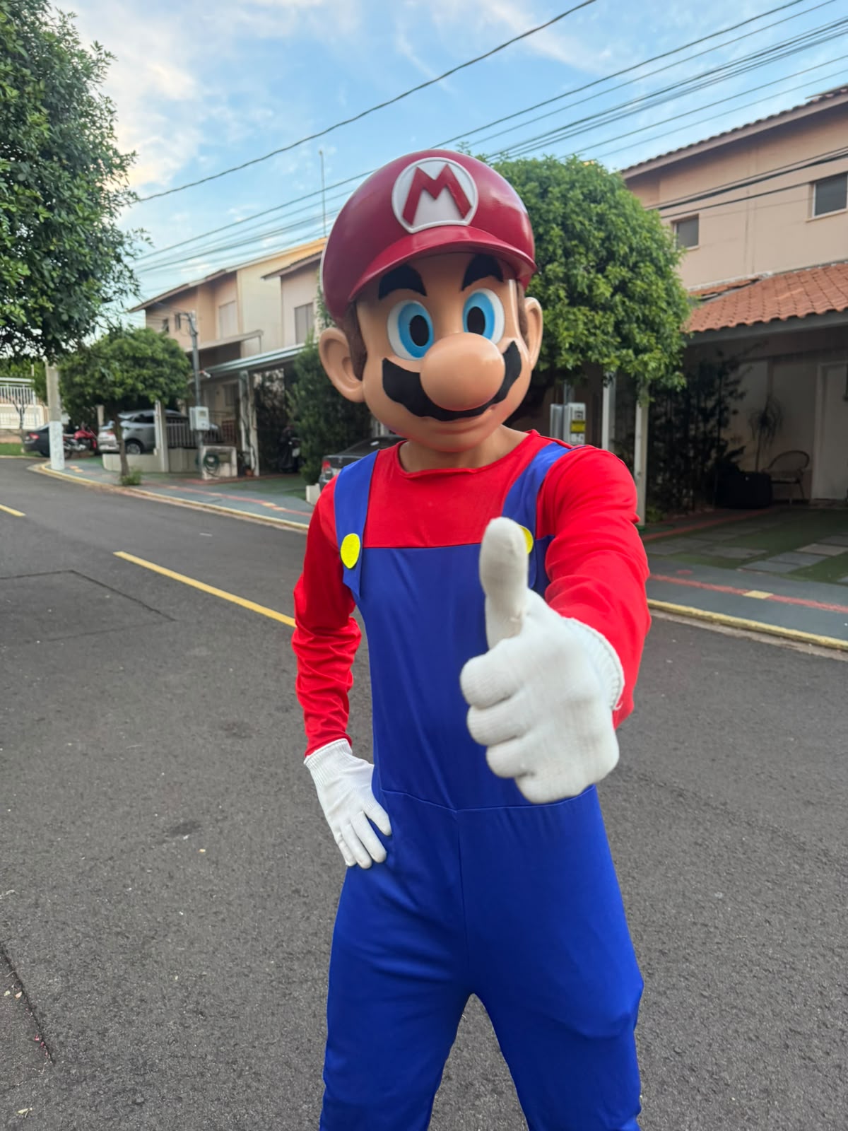 Personagem em pelúcia do Mario acenando na rua