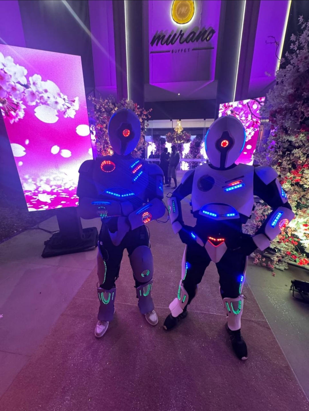 Dupla de robôs de LED na entrada de um buffet
